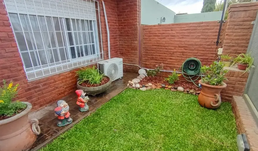 Patio con césped y cantero